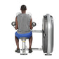 Man seated on blue bench performing dumbbell lateral raise exercise with gray weight machine on white background