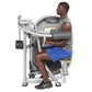 Man using silver Hoist leg press machine, wearing gray tank top and blue shorts, demonstrated on white background