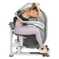 Woman using gray and black abdominal exercise machine with adjustable arm handles, seated on padded seat, wearing lavender le