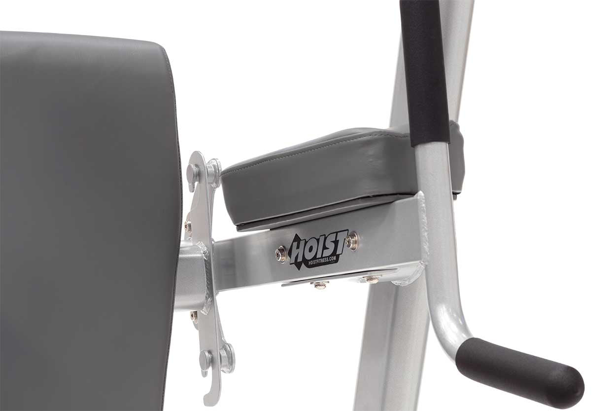 Hoist Fitness weight machine with gray padded seat back, silver metal frame, and black arm rest on white background