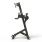 Black upright exercise machine with foot pedals and hand grips on white background