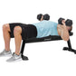 Man performing dumbbell chest press on black Hoist flat utility weight bench with adjustable seat