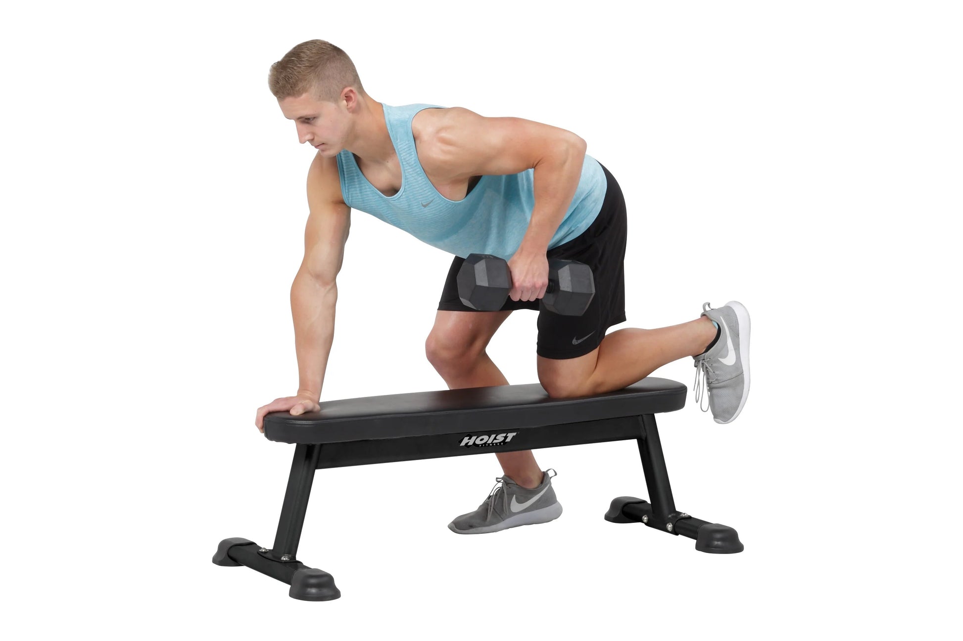 Man performing dumbbell exercise on black Hoist flat utility bench, wearing light blue tank top and black shorts
