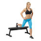 Woman in black sports bra and turquoise capri leggings performing a lunge exercise on a black Hoist flat utility bench agains