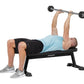Man performing dumbbell bench press on black Hoist flat utility bench with 30-pound weights, wearing light blue shirt and bla
