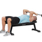 Man performing dumbbell chest press on black Hoist utility bench, wearing light blue tank top and black shorts
