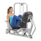 Woman using silver and black Hoist leg press machine with blue footplate and weight stack, demonstrated on white background