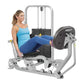 Woman in blue tank top and navy leggings using silver and black Hoist leg press machine with weight stack on white background