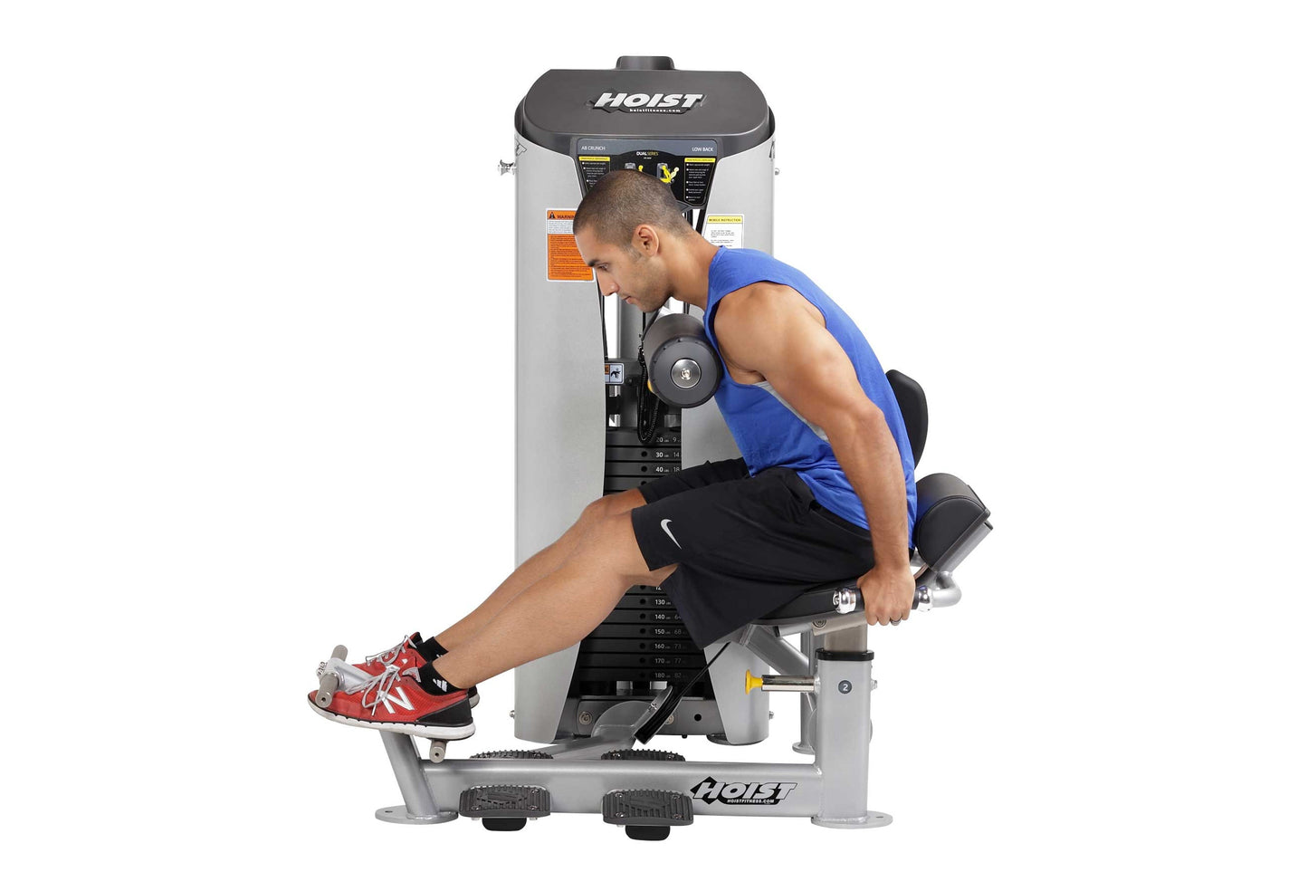 Man in blue tank top and black shorts using Hoist ab crunch machine with leg extension, white and gray frame with dark contro