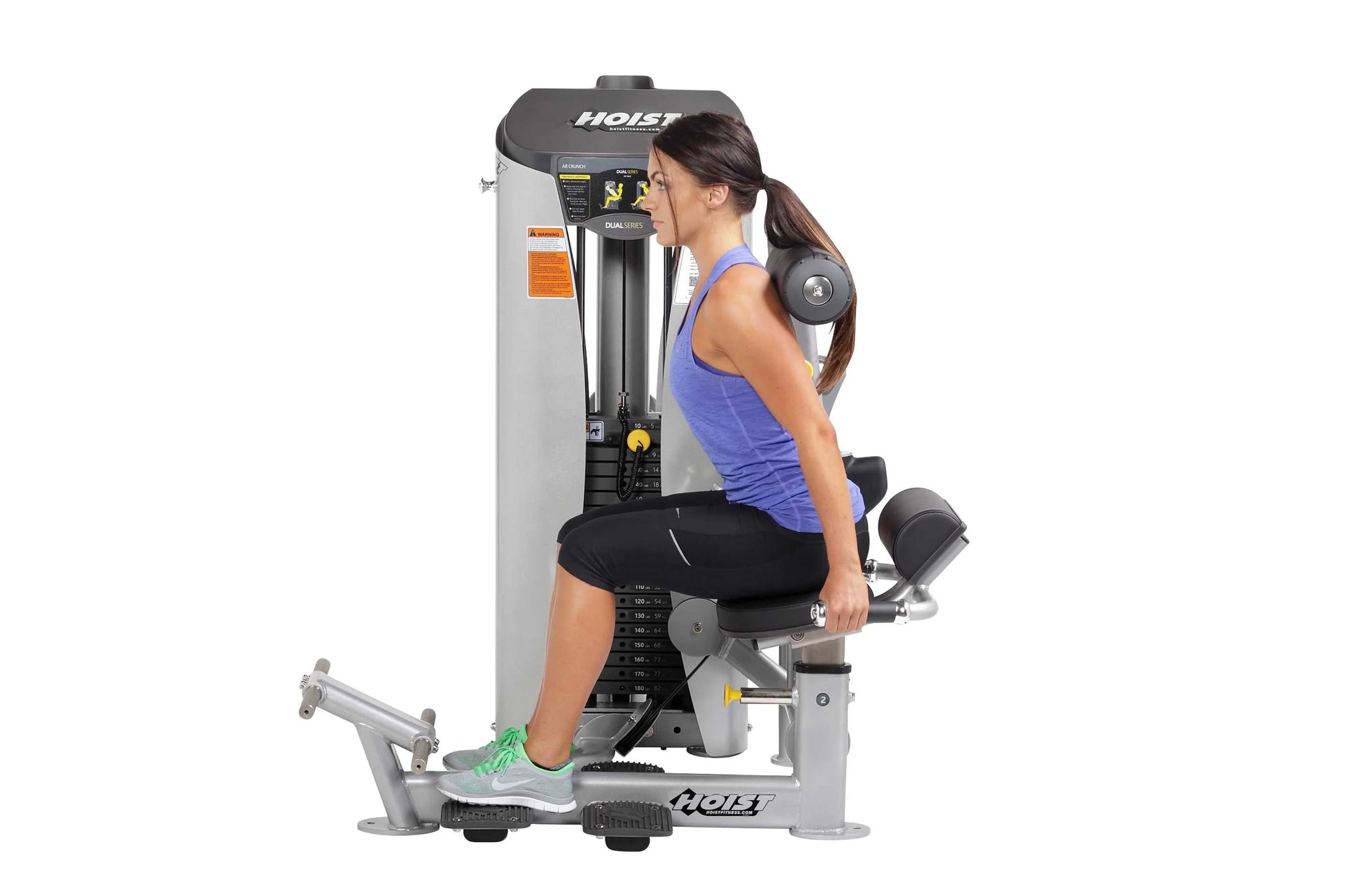 Woman using Hoist Ab Crunch exercise machine with gray and black frame, demonstrating seated abdominal workout position