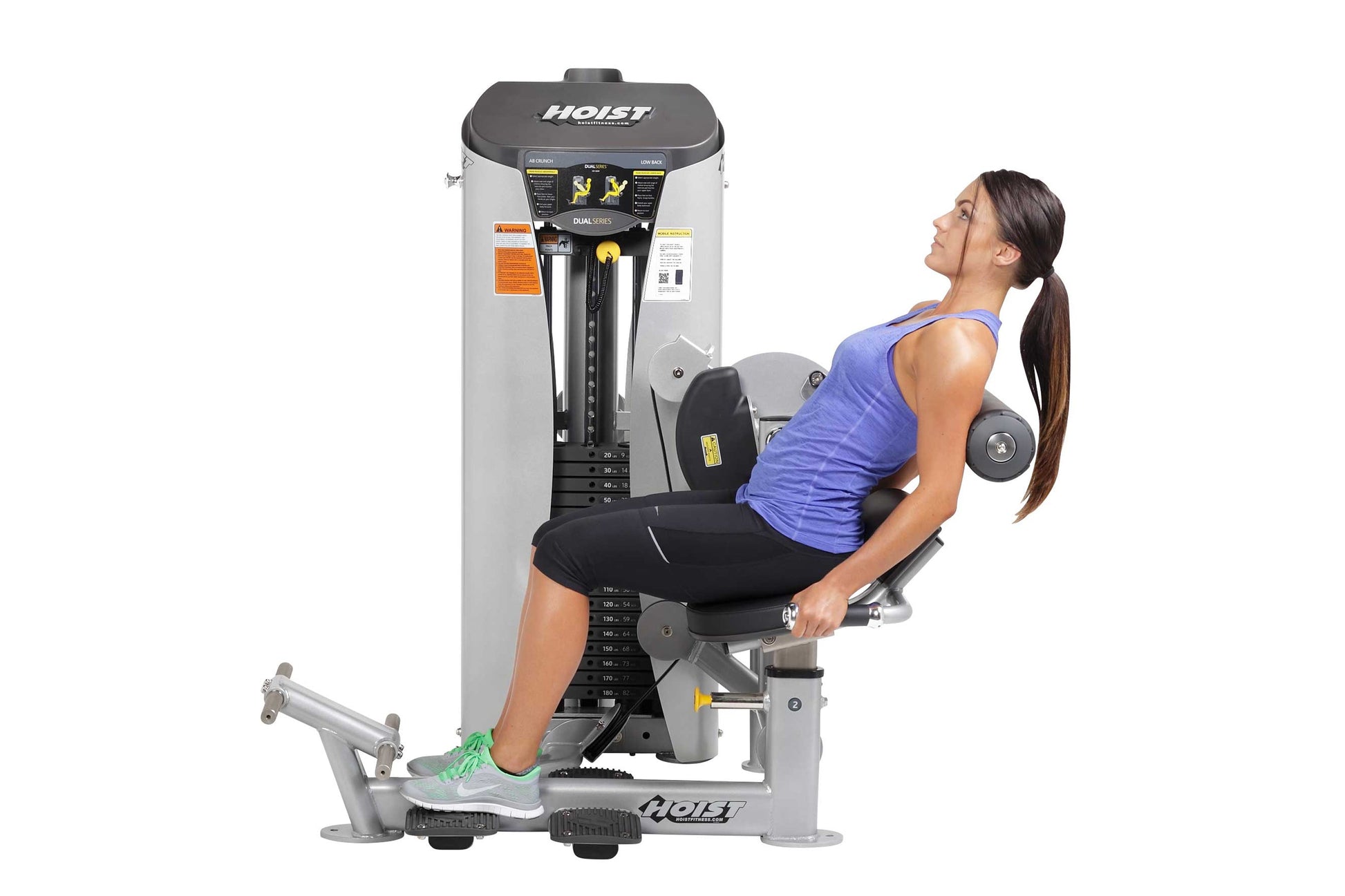 Woman in blue tank top using Hoist Dual Series leg press machine with gray and black frame, shown from side profile on white 