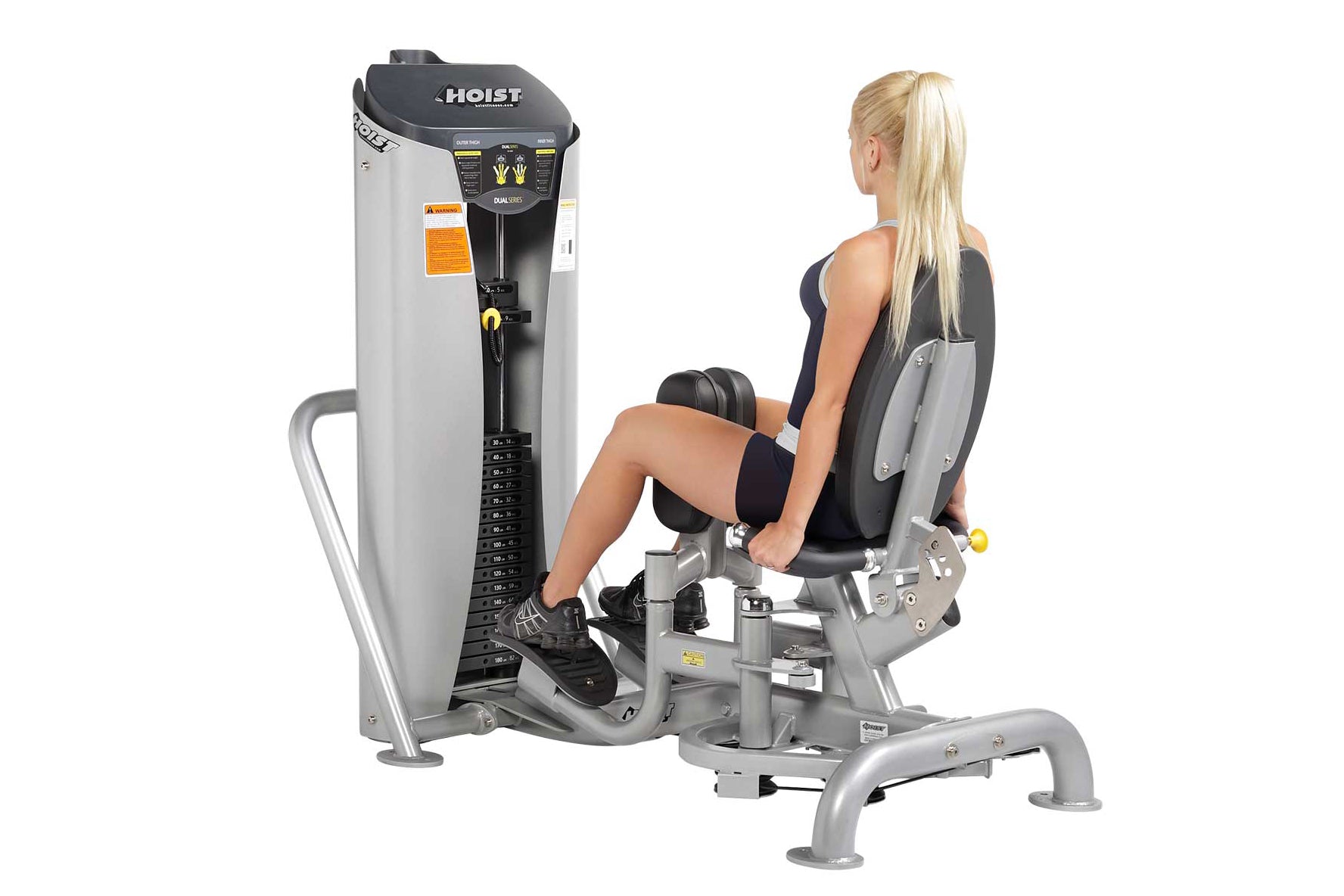 Hoist dual stack leg press machine with gray and black frame, shown in use by woman with blonde hair wearing black athletic t