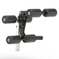 Black and gray leg extension and leg curl attachment with cylindrical rollers and white mounting post, on white background