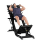 Man using black Hoist leg press and hack squat combo machine, wearing navy t-shirt and shorts on white background