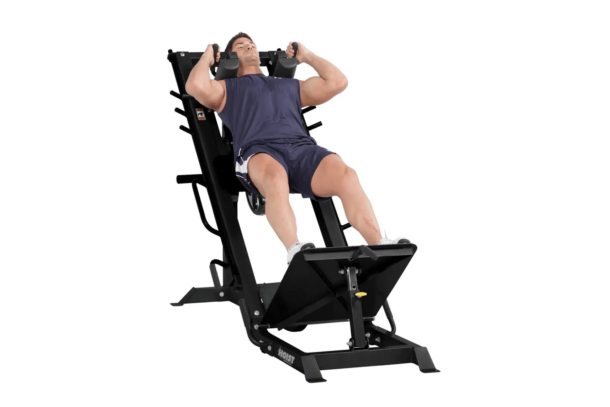 Man using black Hoist leg press and hack squat combo machine, wearing navy t-shirt and shorts on white background