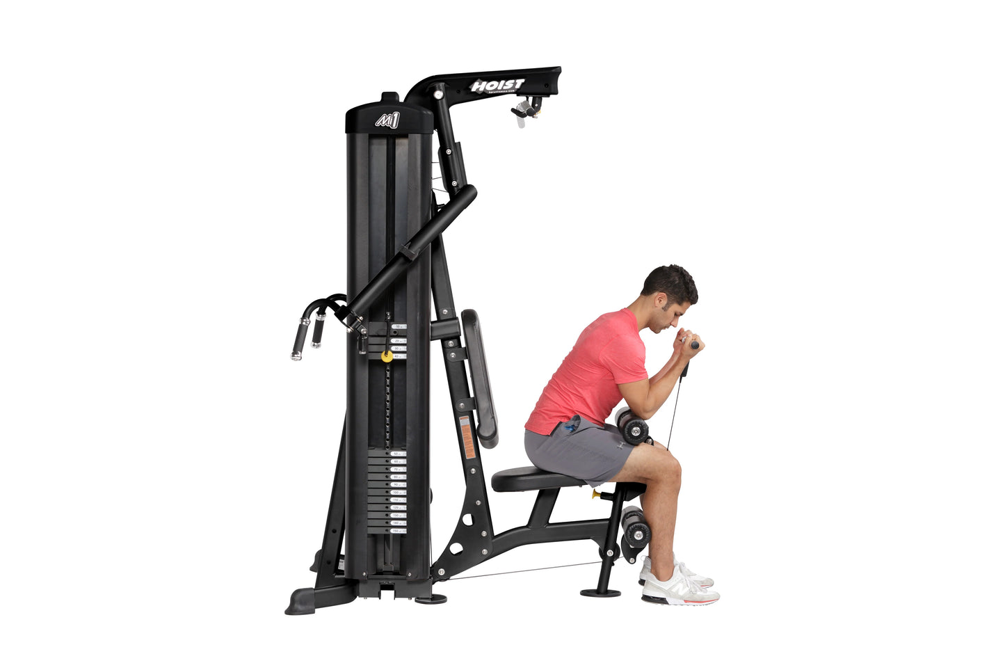Black Hoist Mi1 home gym machine with user in pink shirt performing seated exercise, white background