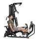 Hoist Mi1 black home gym machine with male model seated performing leg press exercise