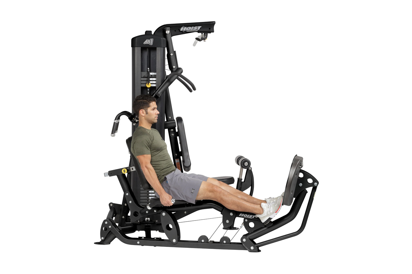 Hoist Mi1 black multi-station home gym machine with seated male model demonstrating leg press position, white background