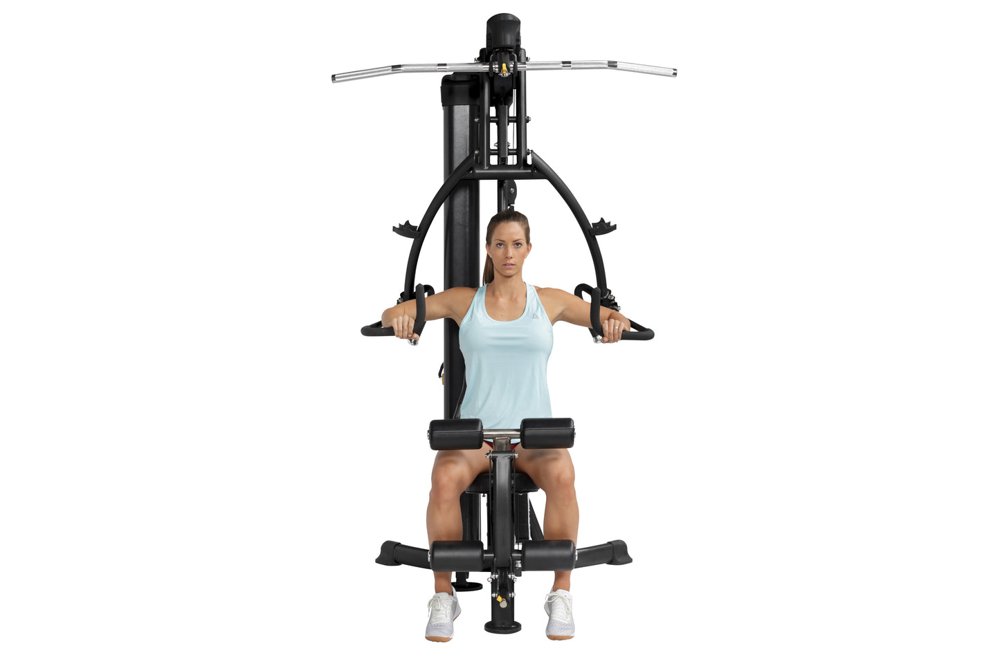Woman in light blue tank top using black Hoist Mi1 home gym machine with horizontal handles and foot platform on white backgr