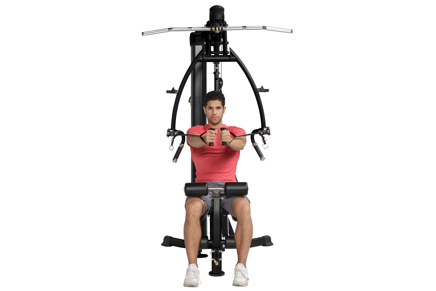 Man in red shirt using black Hoist Mi1 home gym with dual handles and foot pedals, front view on white background