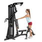 Hoist Mi1 black home gym machine with woman using leg press attachment, white background