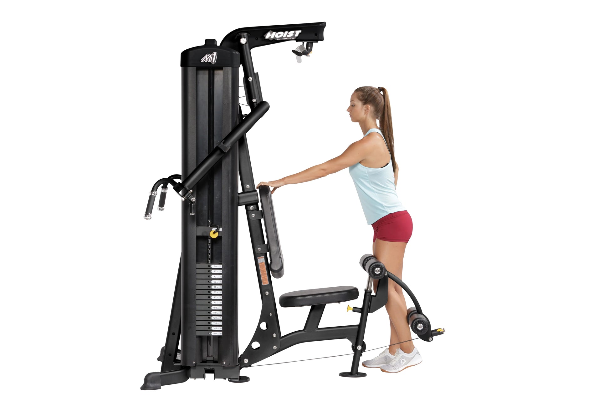 Hoist Mi1 black home gym machine with woman using leg press attachment, white background