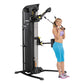 Black and yellow Hoist Mi5 functional trainer with dual cable stations, demonstrated by woman in purple sports bra and blue c