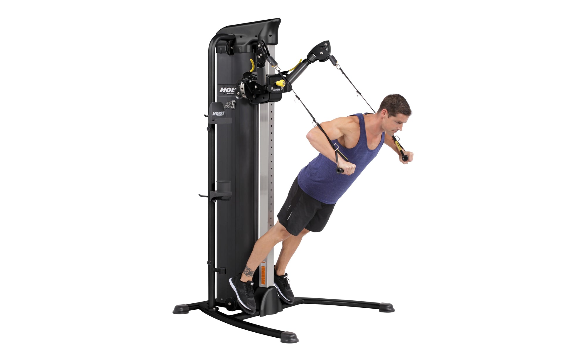Black Hoist Mi5 functional trainer with cable machine system, demonstrated by man in navy tank top performing exercise with h