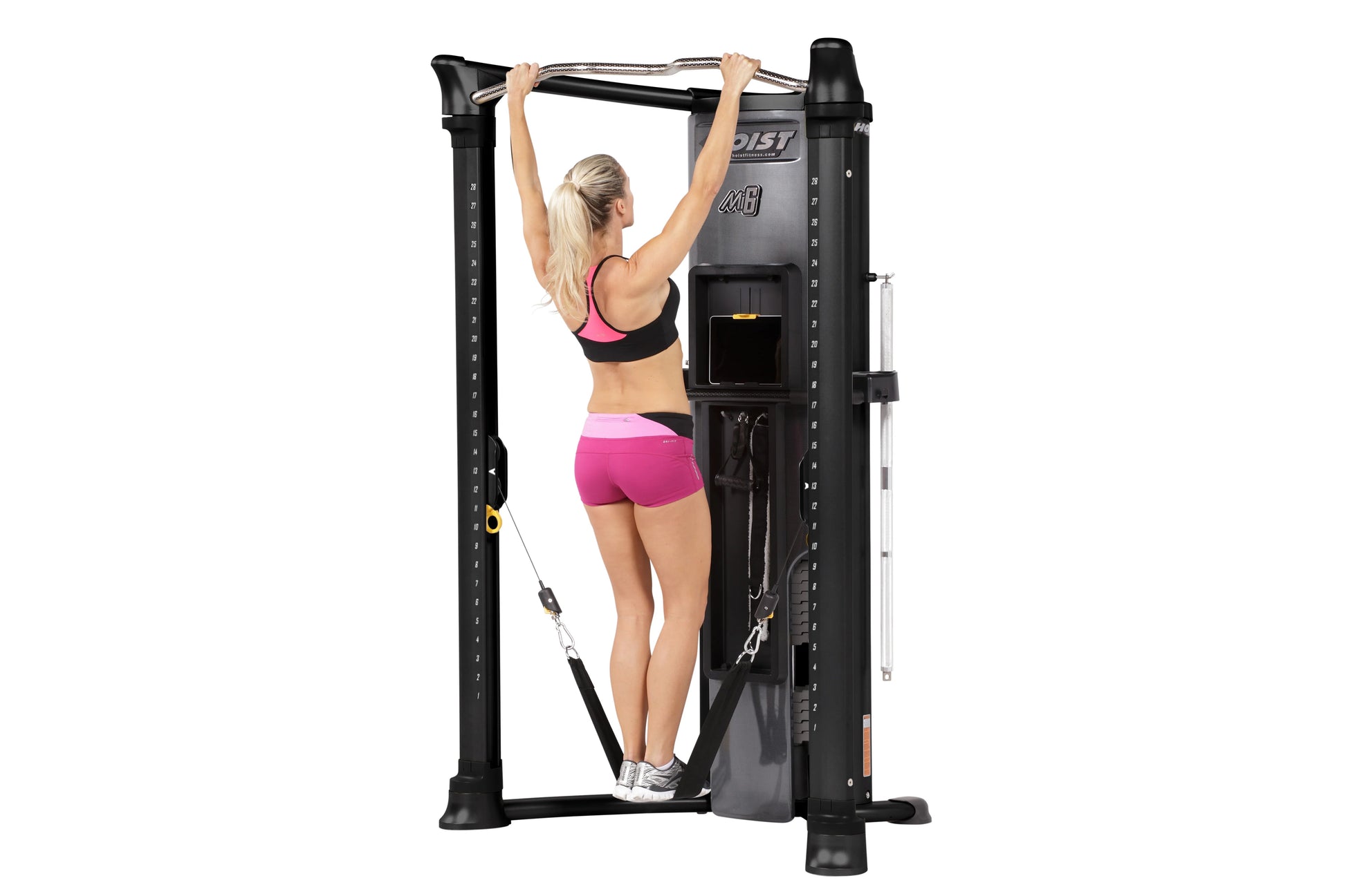 Black Hoist Mi6 functional trainer with model performing pull-up exercise on overhead bar