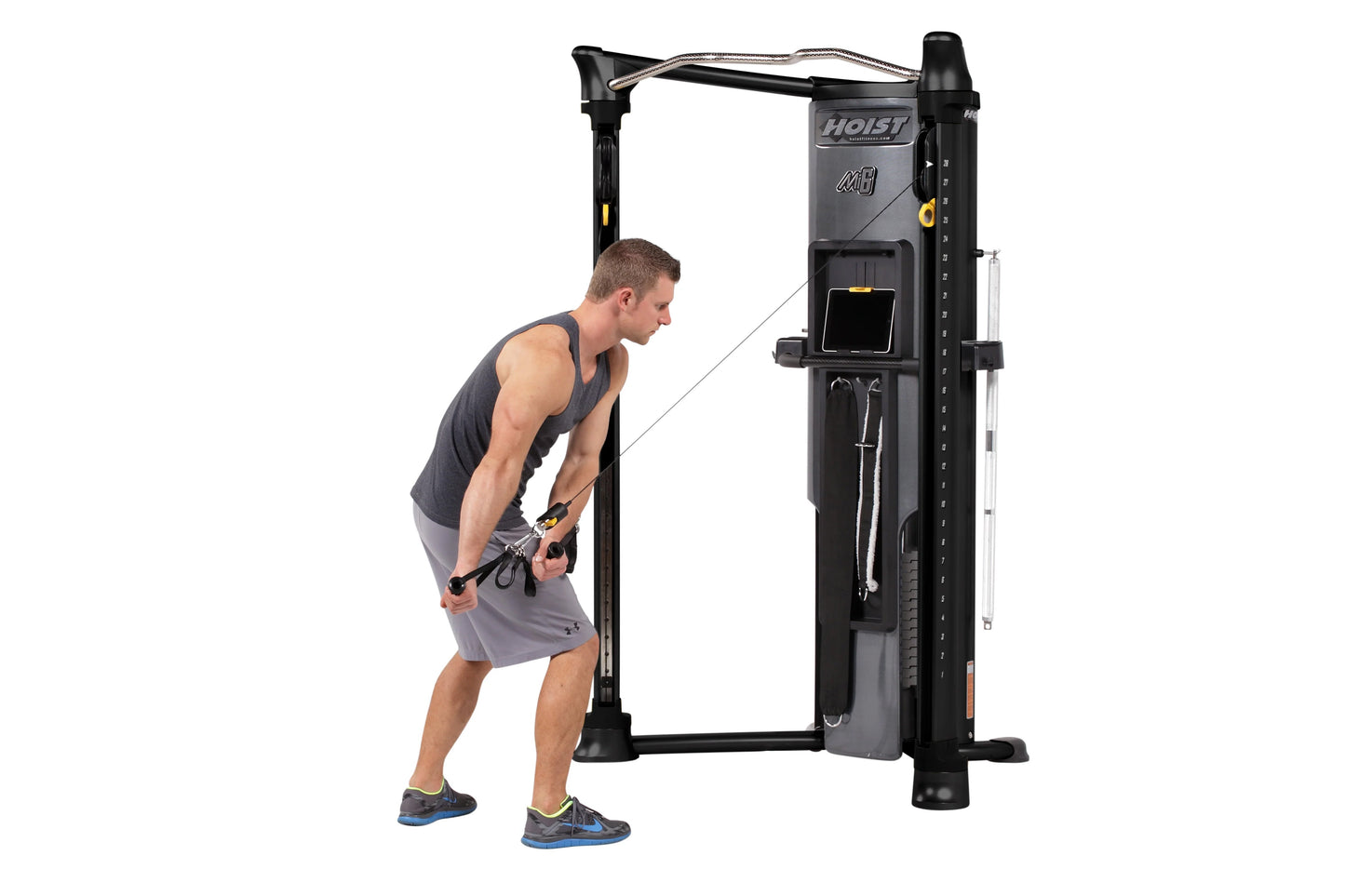 Hoist Mi6 Functional Trainer in black with gray accents, demonstrated by male model using cable attachment for exercise