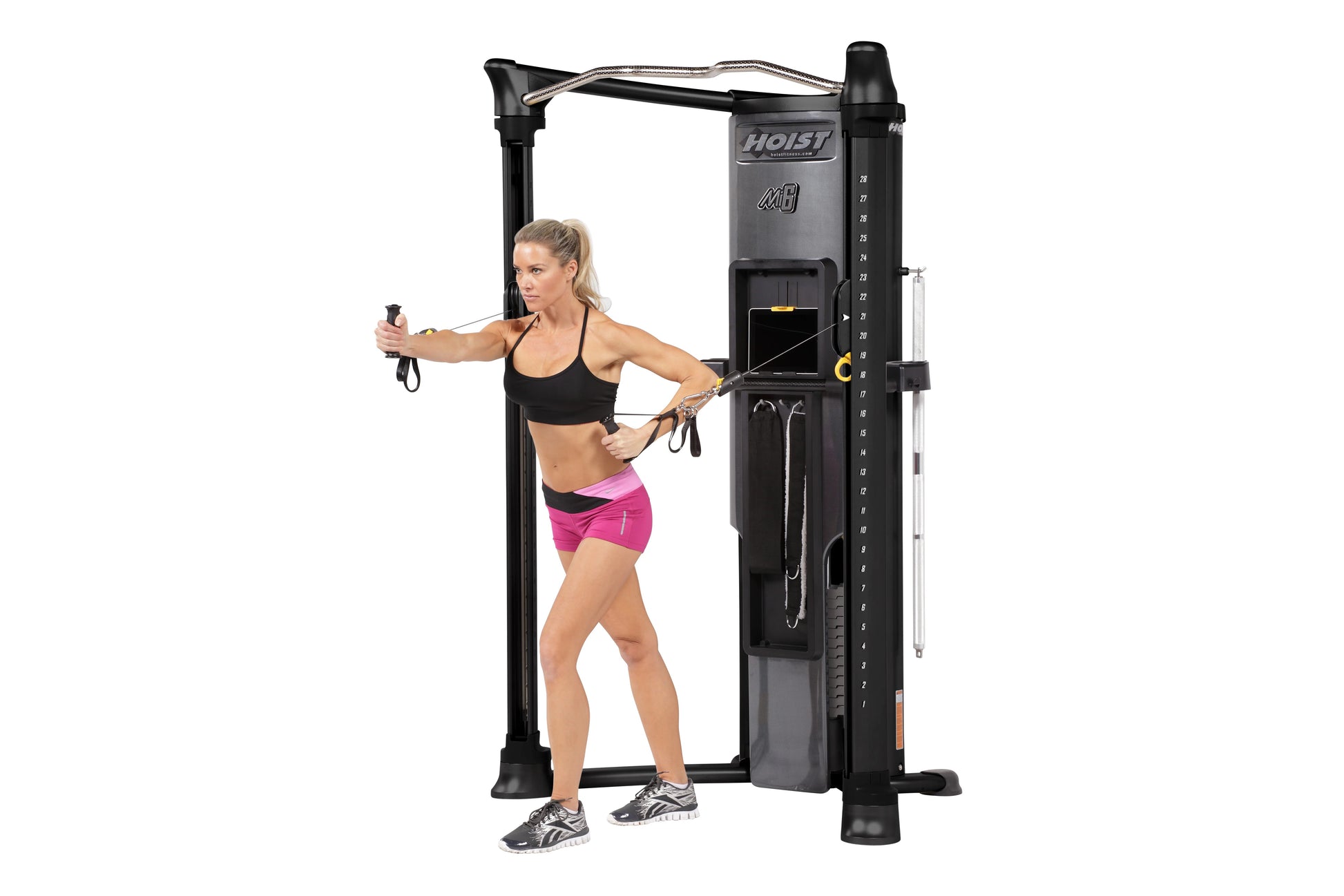 Hoist Mi6 Functional Trainer Home Gym in black with dual weight stacks, shown in use by model wearing black sports bra and pi