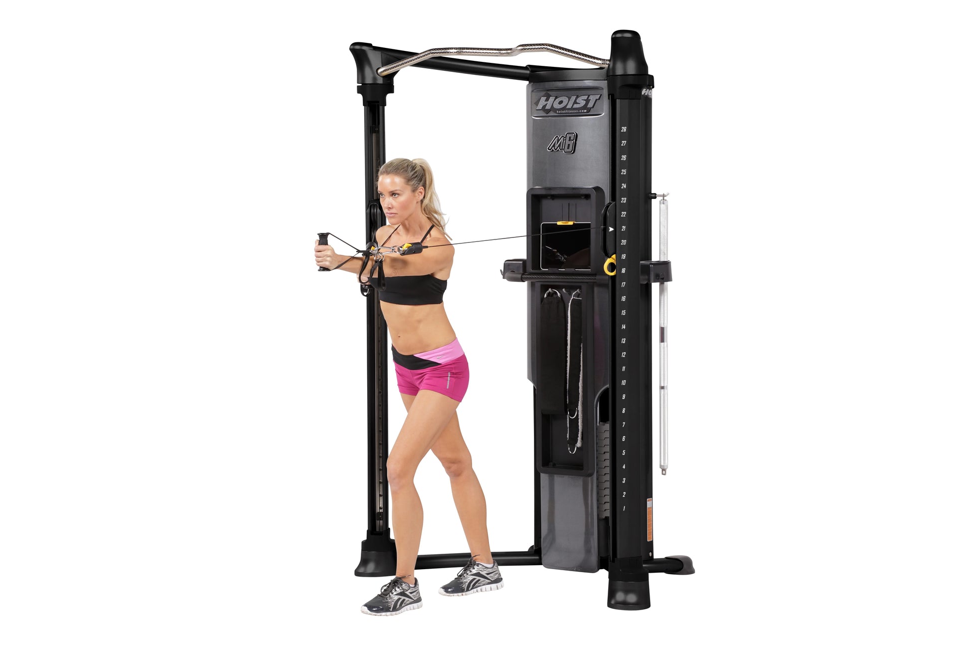 Hoist Mi6 functional trainer home gym with black frame and gray accents, shown in use by model on white background