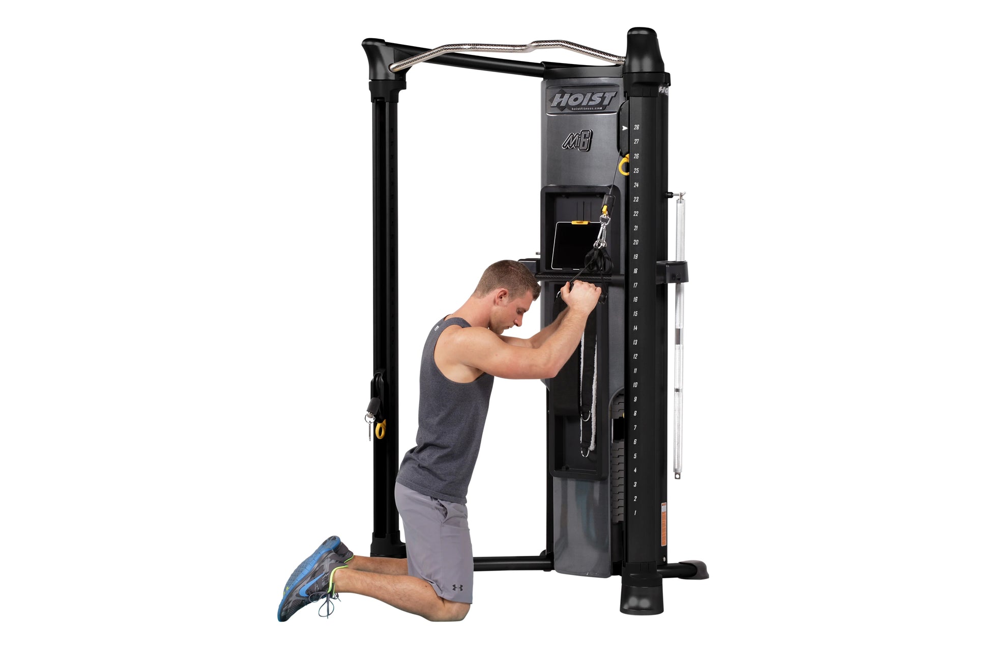 Hoist Mi6 functional trainer with black frame and silver top bar, shown with male model performing chest press exercise on wh