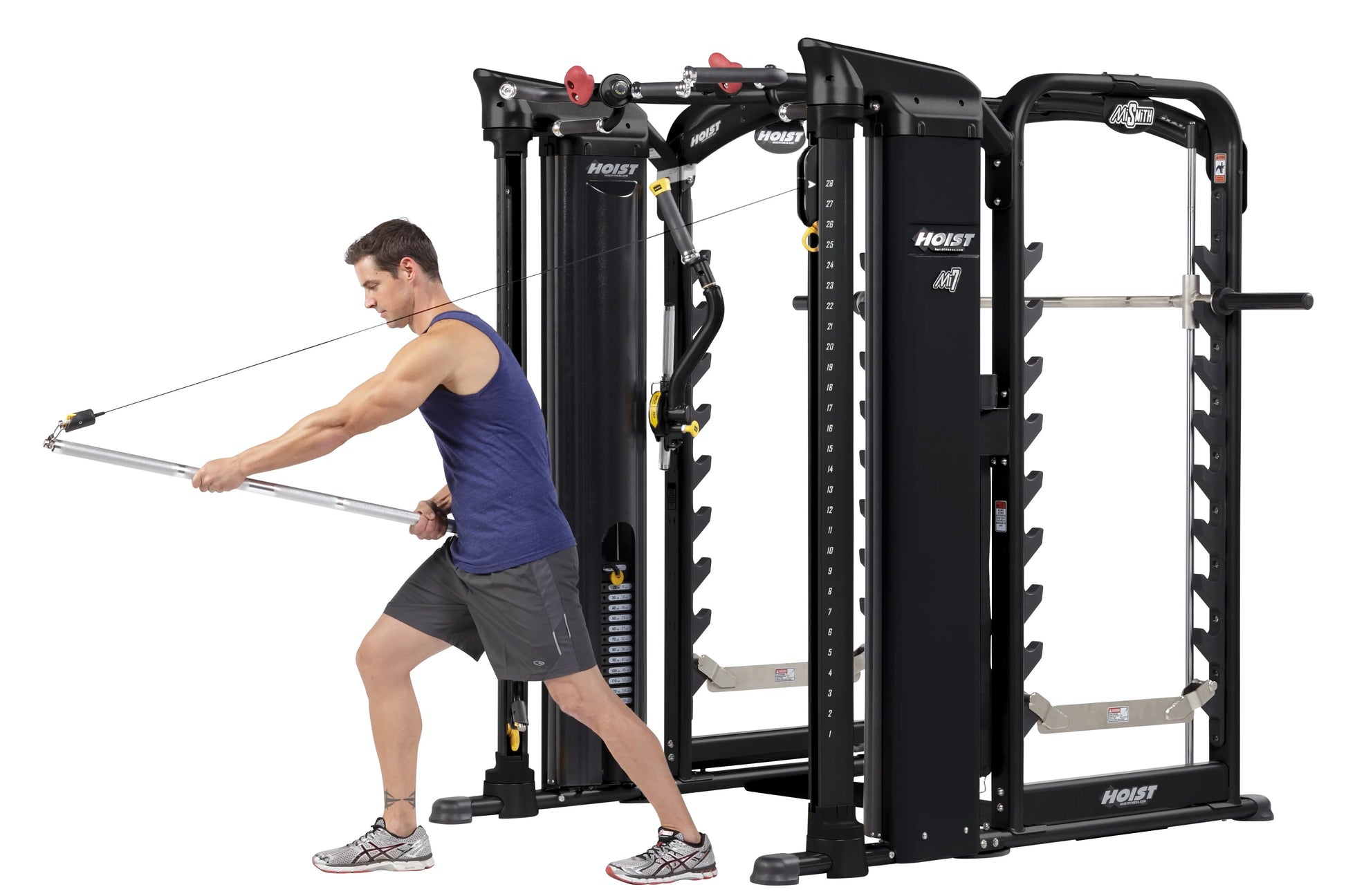 Man using black Hoist MI7 Smith functional trainer machine with cable attachment, demonstrating chest exercise on white backg