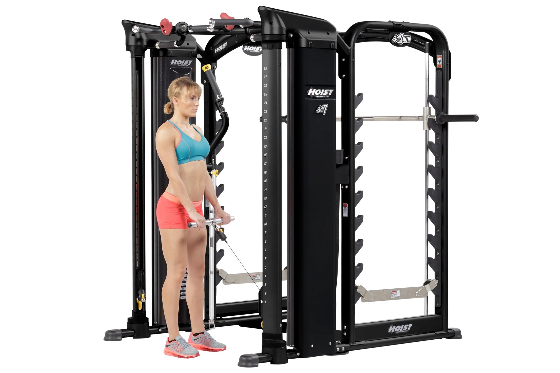 Hoist MI7 black functional trainer and smith machine with woman in blue sports bra and coral shorts demonstrating use