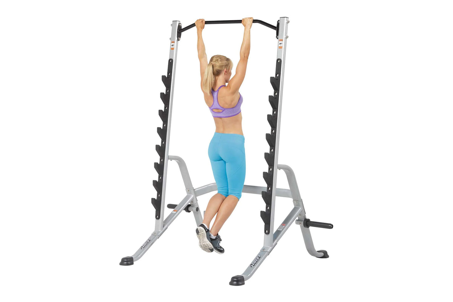 Silver and black multi-purpose squat rack with pull-up bar, shown with woman demonstrating pull-up exercise on white backgrou