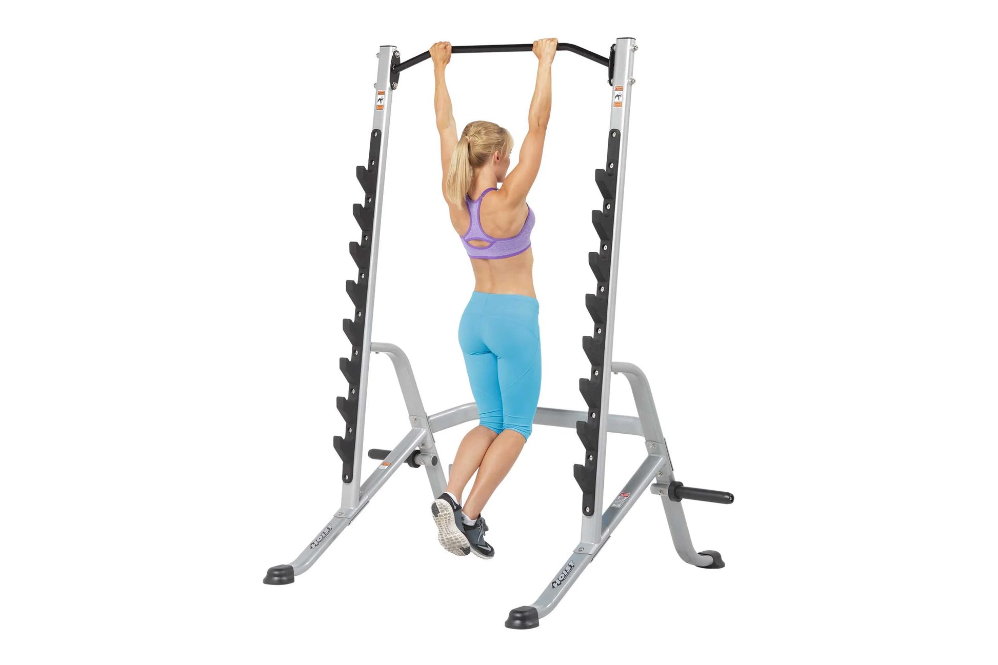 Silver and black multi-purpose squat rack with pull-up bar, shown with woman demonstrating pull-up exercise on white backgrou