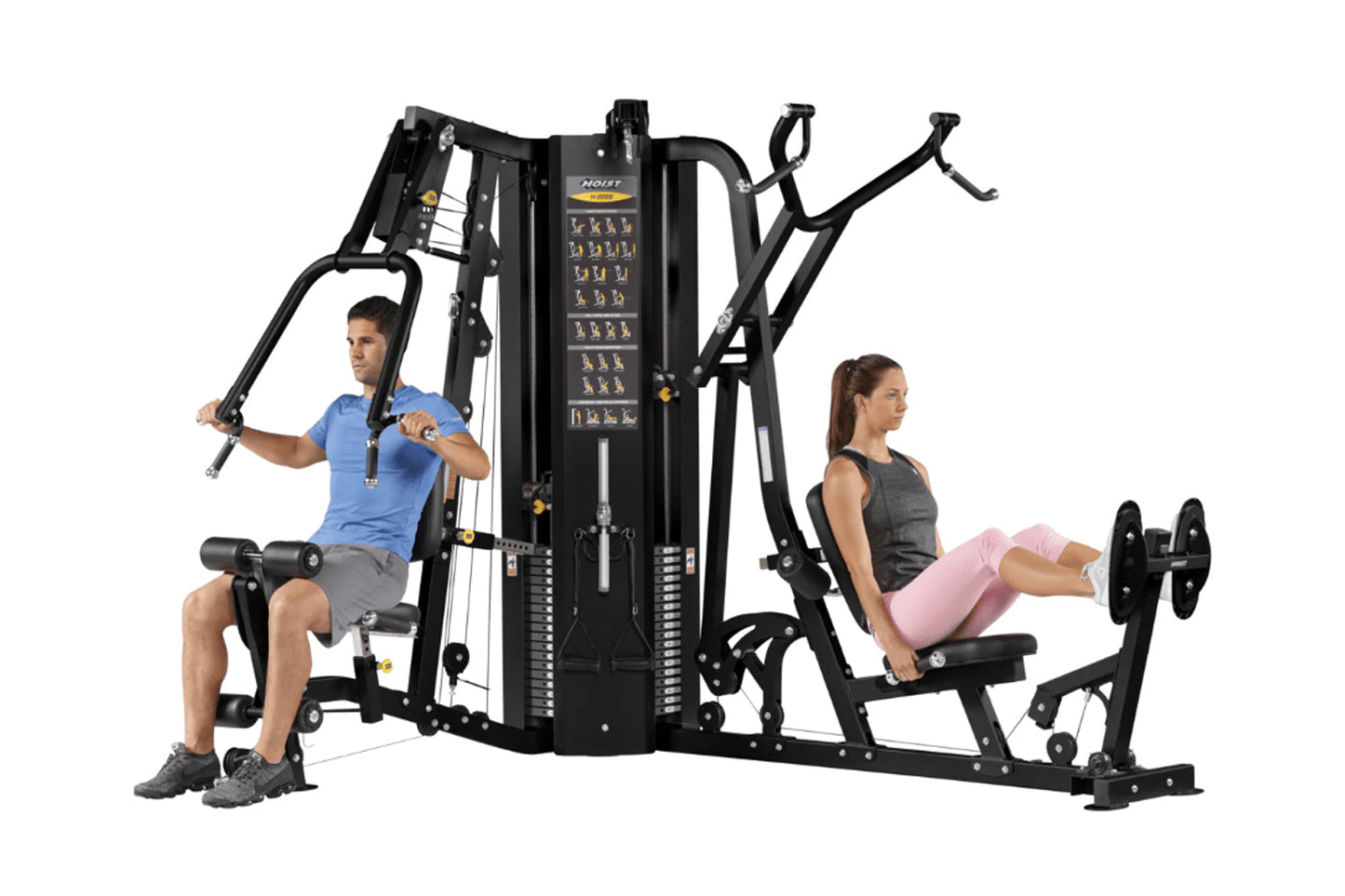 Black multi-station gym equipment with two users demonstrating exercises, featuring stacked weight plates and instruction pan