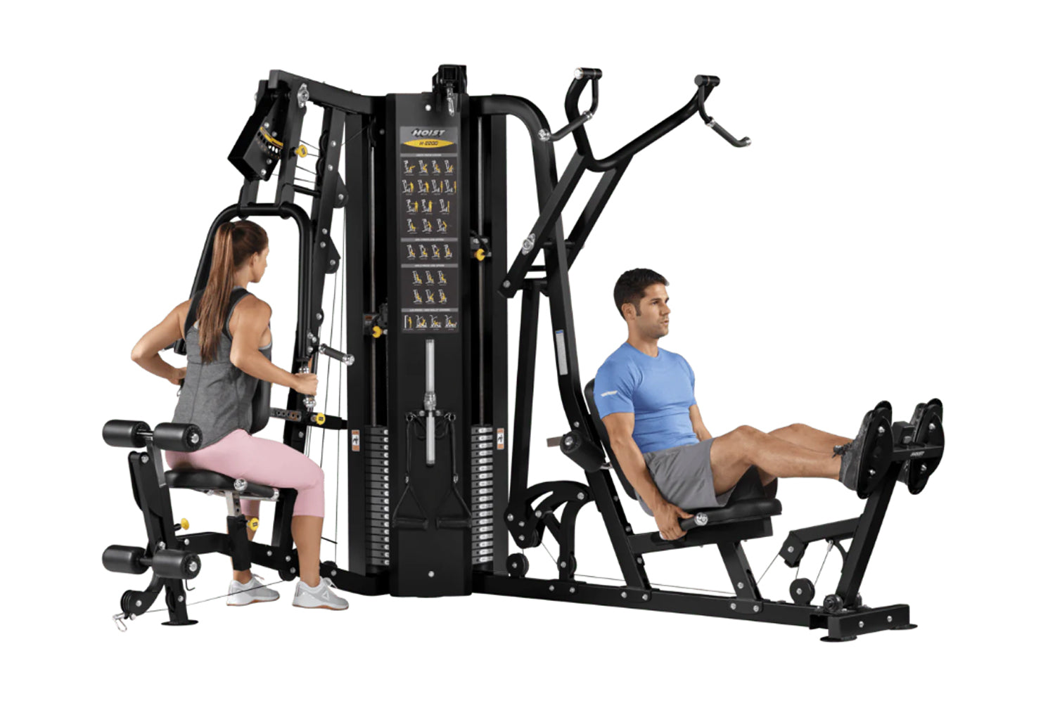 Black multi-station gym equipment with two users demonstrating exercises, featuring weight stacks and instruction panels on w