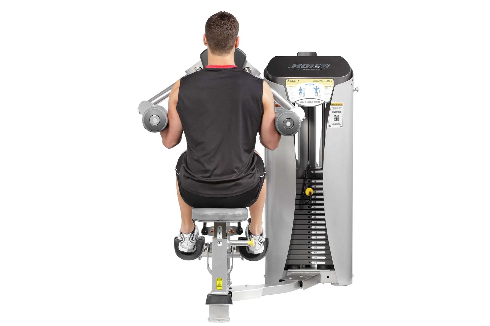 Male user performing lateral raise exercise on silver and black Hoist ROC-IT machine with weight stack, viewed from behind