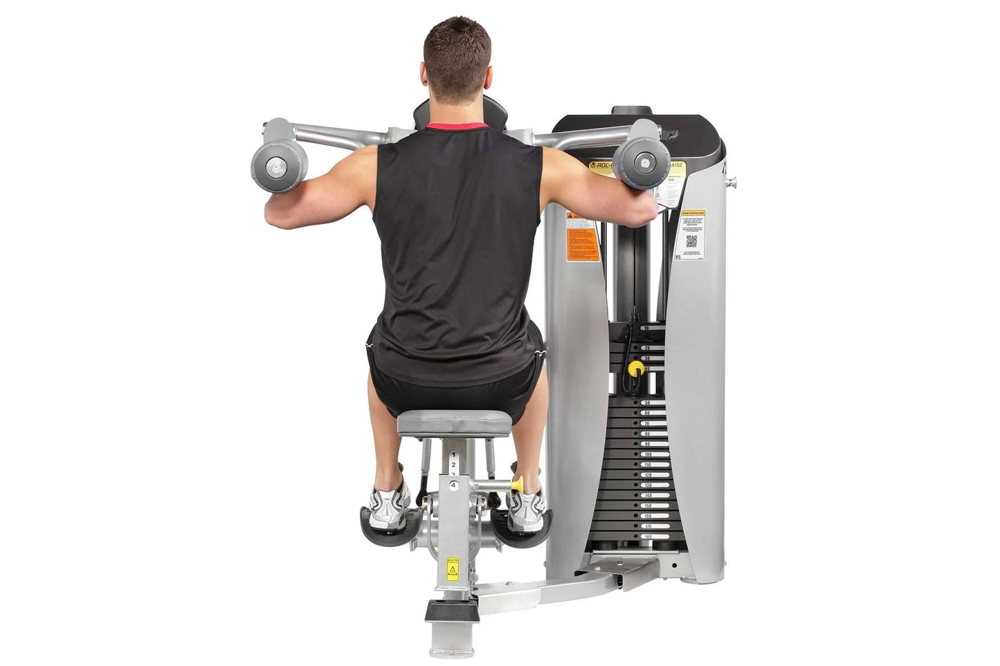 Male athlete using Hoist ROC-IT lateral raise machine, silver and black exercise equipment with dual handles, worn on white b