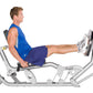 Male athlete in blue tank top and navy shorts using silver Hoist ROC-IT Ride leg press machine with extended leg position on 
