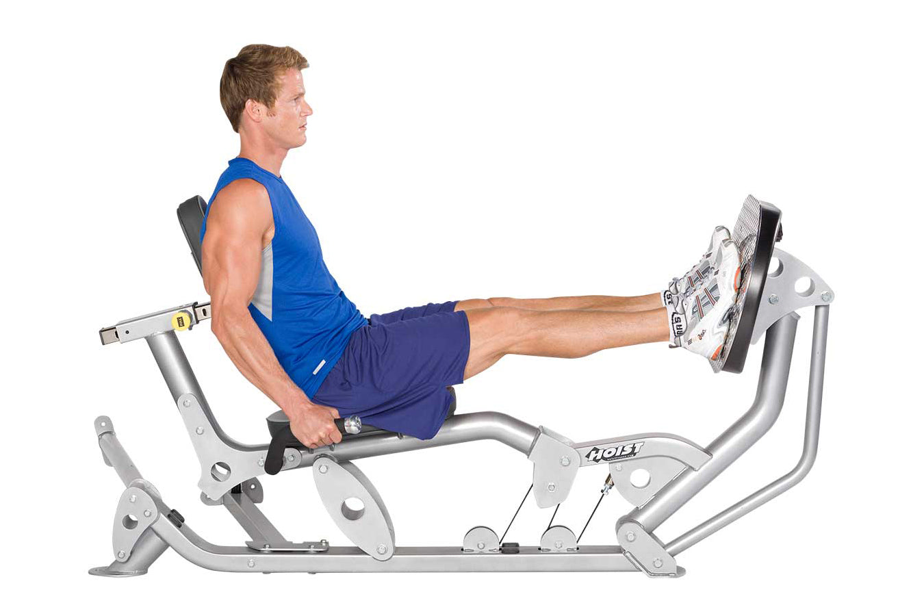 Male athlete in blue tank top and navy shorts using silver Hoist ROC-IT Ride leg press machine with extended leg position on 