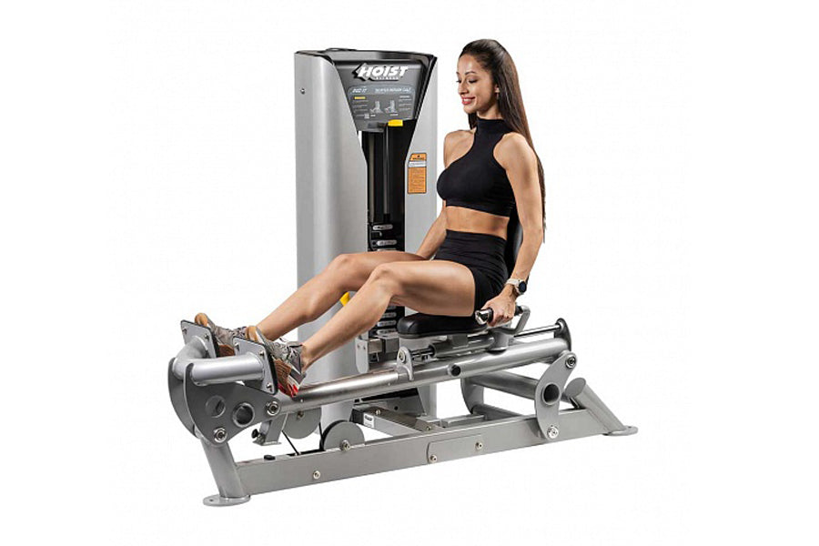 Woman using silver and black Hoist ROC-IT rotary calf exercise machine with leg extended on footplate