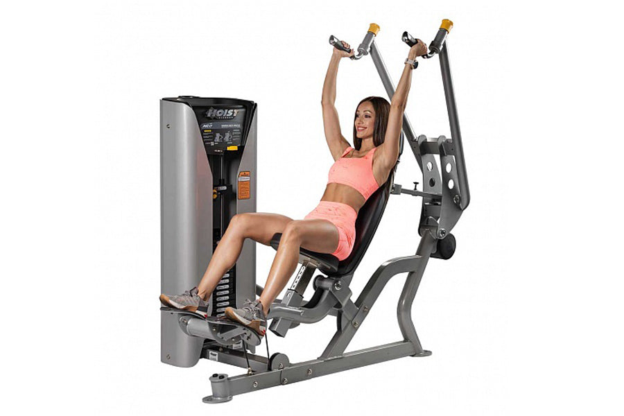Hoist ROC-IT shoulder press machine with gray frame and black seat, demonstrated by woman in pink athletic wear on white back