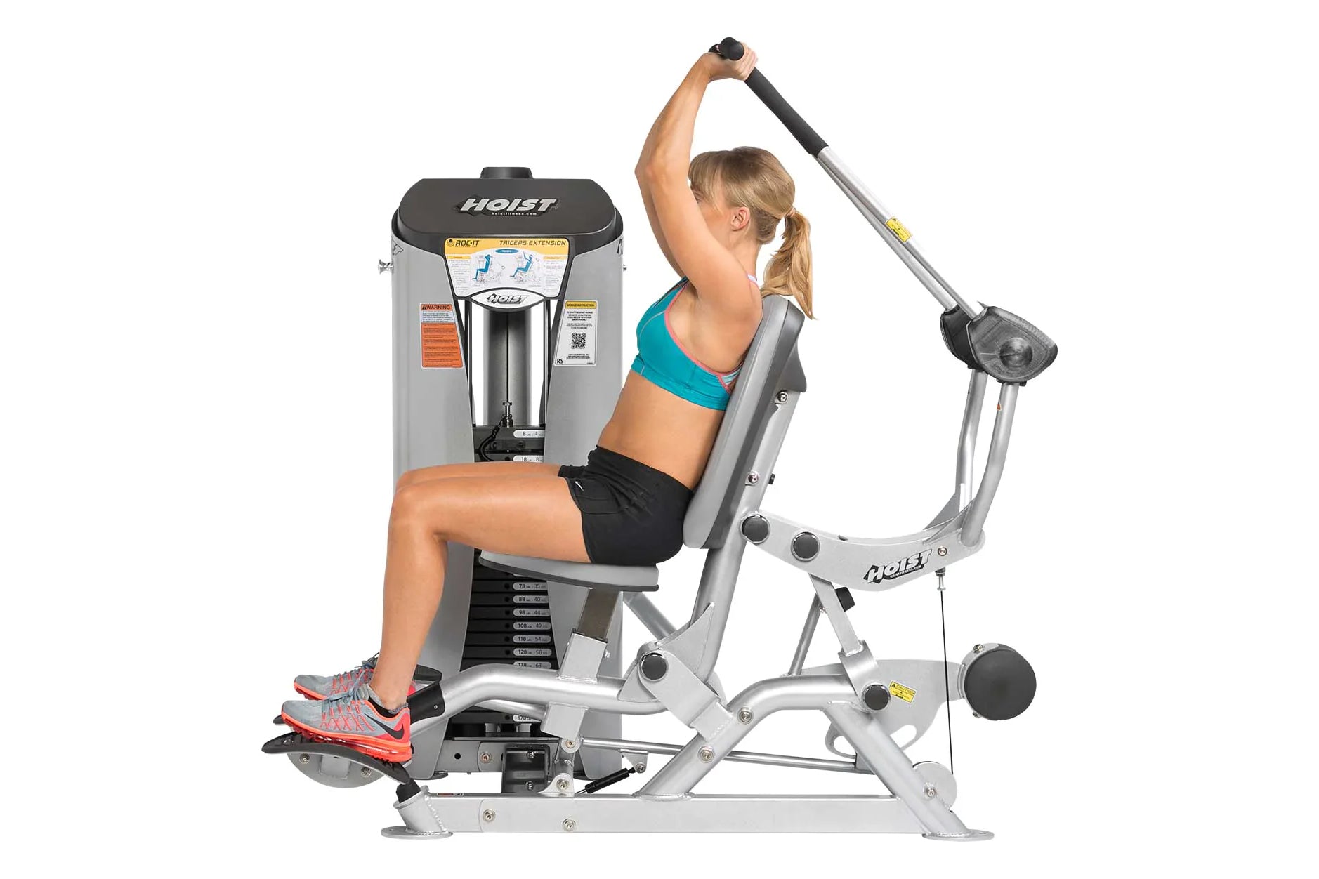 Hoist ROC-IT Triceps Extension Machine with silver frame, demonstrated by woman in turquoise sports bra performing triceps ex