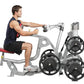 Man using silver Hoist ROC-IT biceps curl machine with black weight plates, demonstrating seated arm exercise on white backgr