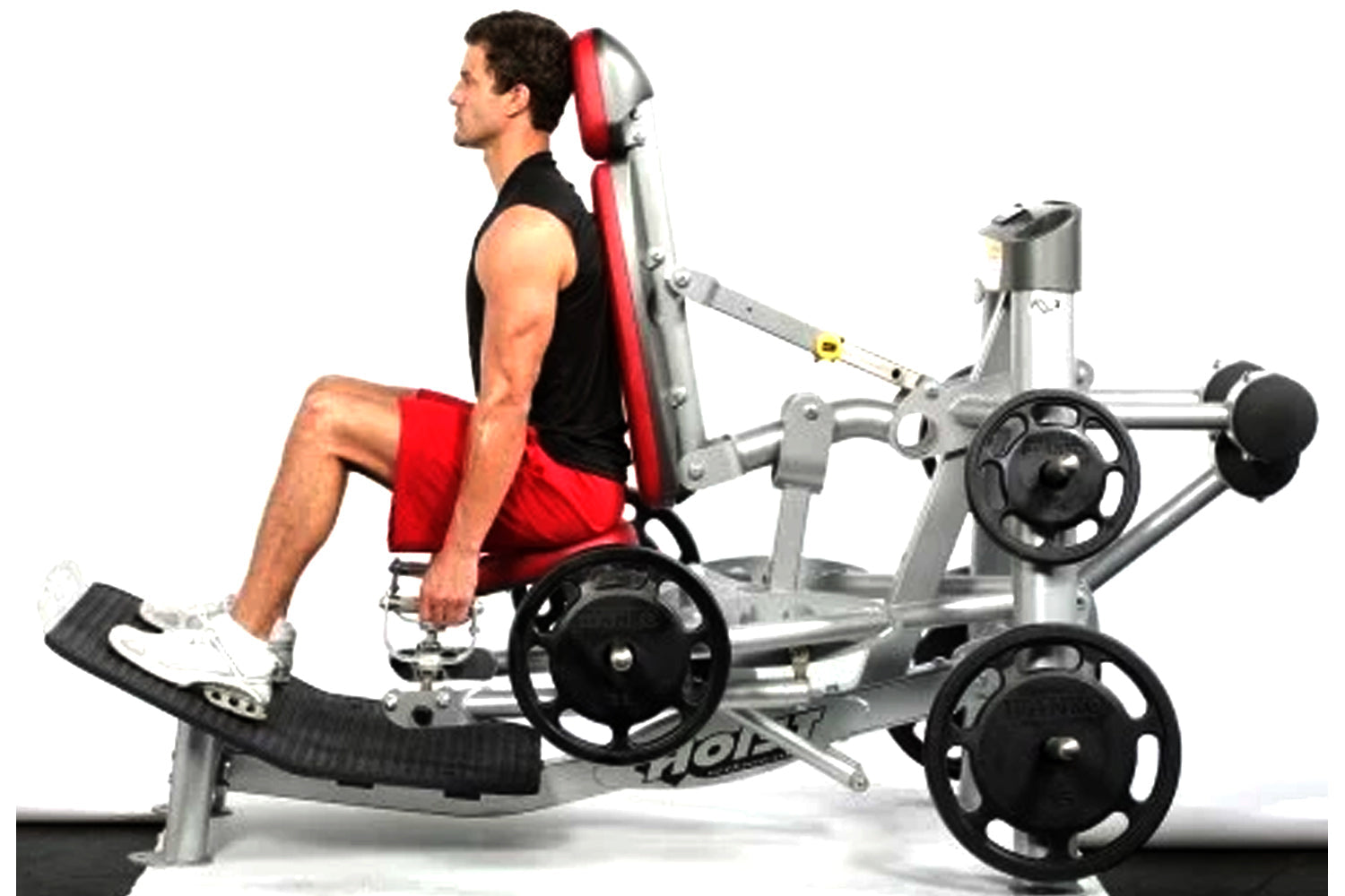 Man using silver and red Hoist ROC-IT leg press machine with black weight plates, wearing red shorts and black tank top