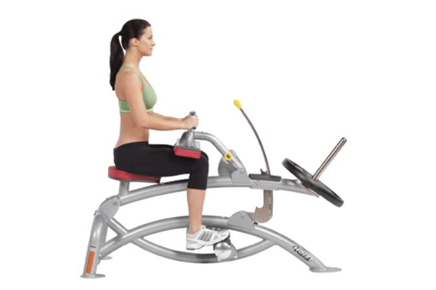 Woman in green sports bra and black capris using silver Hoist seated calf raise machine with foot pedal on white background