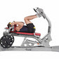 Person using gray and red Hoist Dual Action Leg Press machine with black weight plate, demonstrating seated leg exercise posi